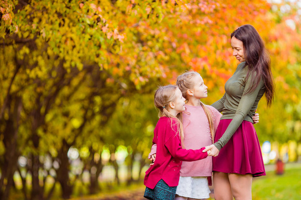 Little girl with mom outdoors in park at autumn day - Photo, Image