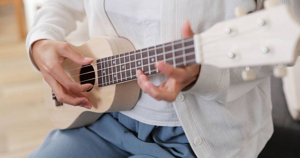 Nő játék ukulele otthon - Fotó, kép