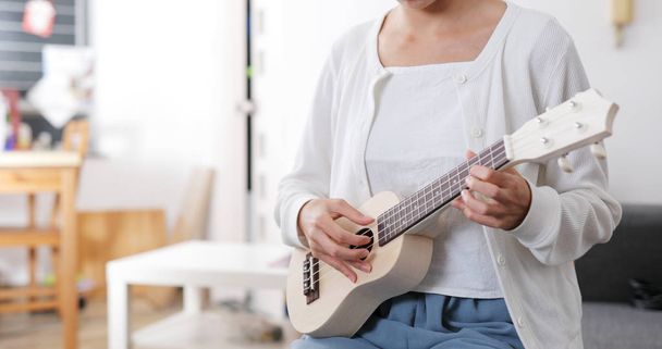 Woman play a music on ukulele - Φωτογραφία, εικόνα