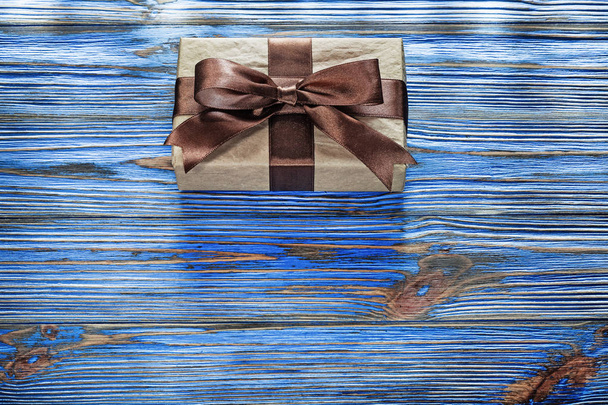 Wrapped brown present box on vintage wooden board - Фото, изображение