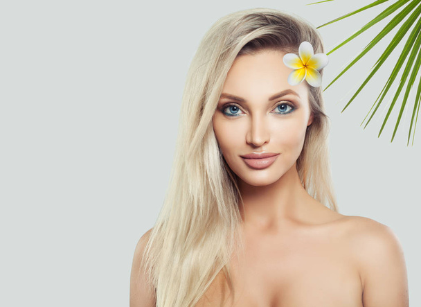 Blondi nainen spa malli terve iho ja trooppisia lehtiä ja kukka valkoisella pohjalla
 - Valokuva, kuva