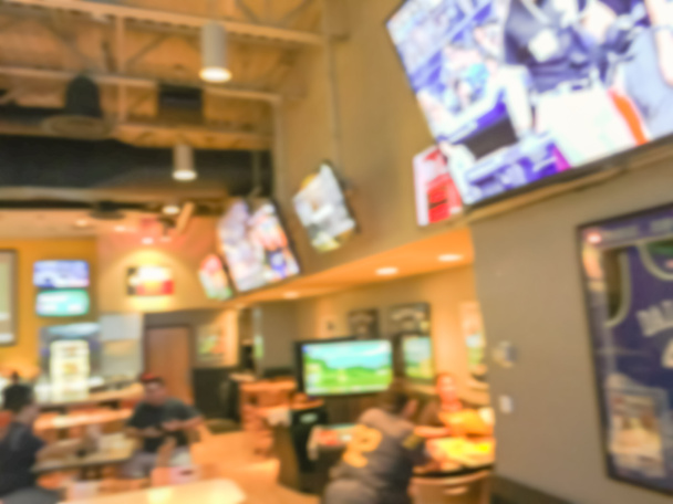 Niewyraźne Abstrakcja sportowe bary Restauracje w Stany Zjednoczone Ameryki. Rozmyte ludzi oglądać wydarzenia sportowe, pić piwo i jeść kuchnia amerykańska - Zdjęcie, obraz