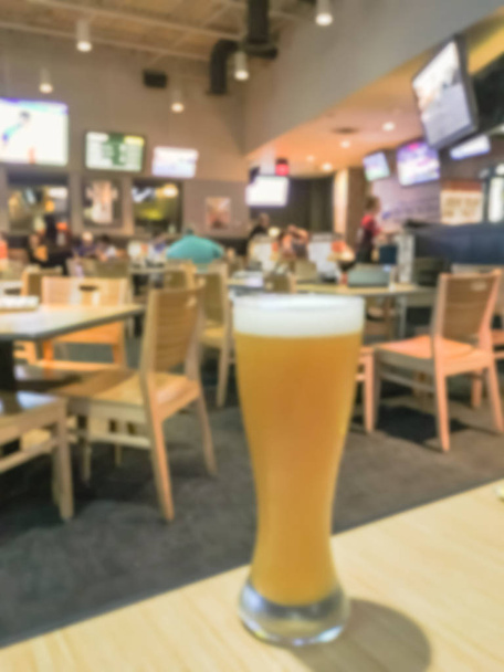 Cerveza de trigo fresca abstracta borrosa en vasos weizen en restaurante informal y bar deportivo en América
 - Foto, Imagen