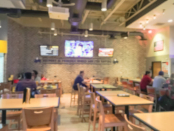 Blurred bar counter at sports bars and restaurants in USA. Large wall mount flat-screen TV, classic wooden table, chair. People drink craft beer, hanging out, watching sport - Photo, Image