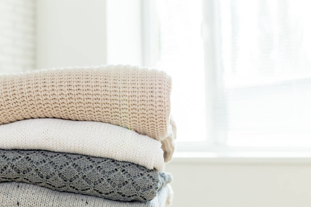 Stack of white cozy knitted sweaters , close-up  - Foto, immagini