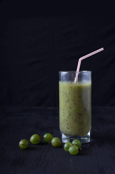 smoothies from gooseberry in a glass of styot on a black table - Fotó, kép