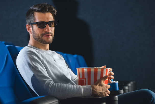 side view of young man in 3d glasses with popcorn in cinema - Valokuva, kuva