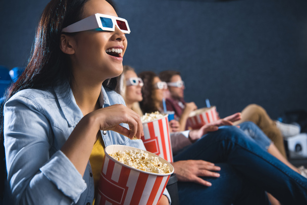 счастливая азиатская женщина в 3D очки с попкорном смотреть фильм в кино
 - Фото, изображение