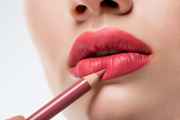 cropped view of woman applying lip pencil,  isolated on white  - Photo, Image