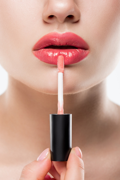 vista recortada de la mujer que aplica brillo labial rosa, aislado en blanco
 - Foto, imagen