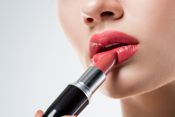 cropped view of woman applying pink lipstick,  isolated on white - Photo, Image