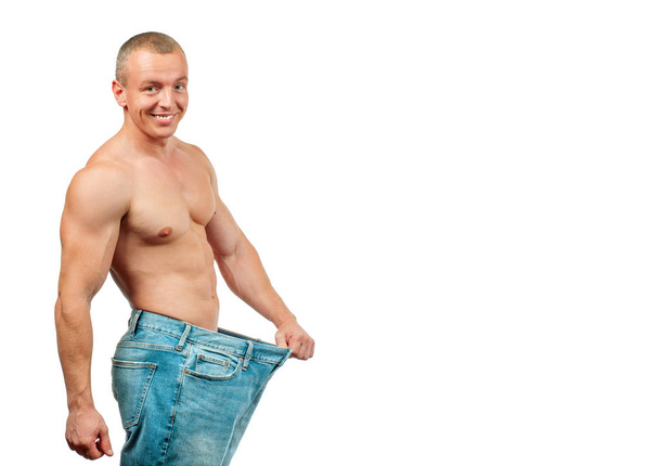 Homme portant de gros jeans après l'alimentation, concept de perte de poids
 - Photo, image