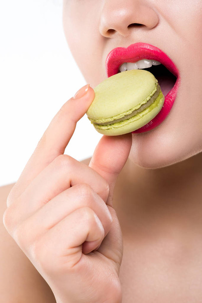 vista recortada de la mujer comiendo macaron verde dulce, aislado en blanco
 - Foto, imagen
