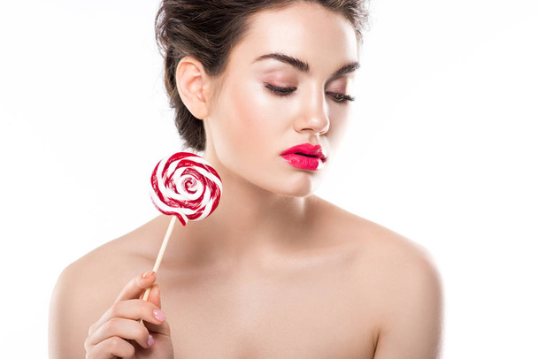 tender woman with closed eyes holding red lollipop, isolated on white - Фото, зображення