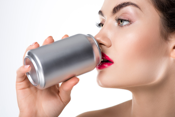 attractive fashionable girl drinking soda from can, isolated on white - Fotoğraf, Görsel