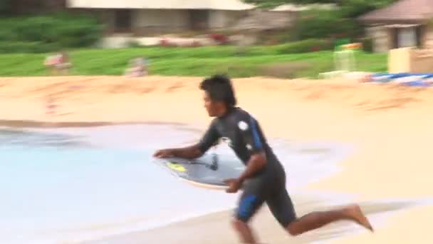Man surfing on the beach - Felvétel, videó