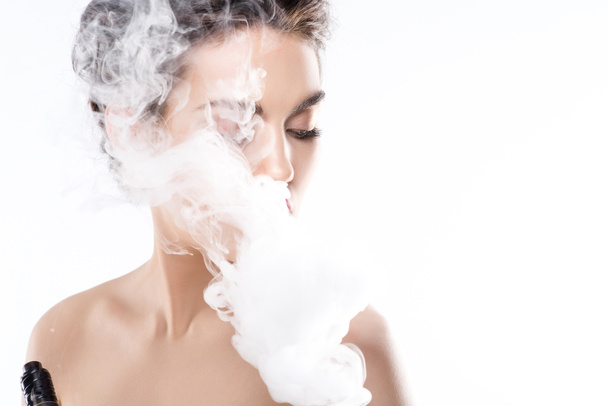 attractive woman vaping and blowing smoke, isolated on white - Fotoğraf, Görsel
