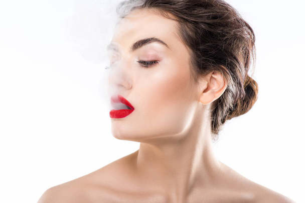 beautiful fashionable woman blowing smoke, isolated on white - Foto, Bild