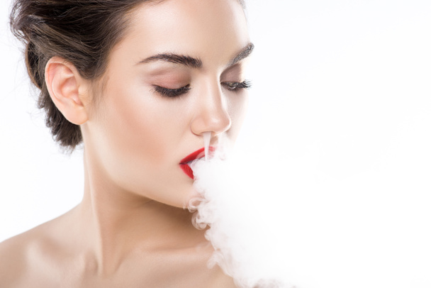 atractiva joven mujer soplando humo, aislado en blanco
 - Foto, imagen