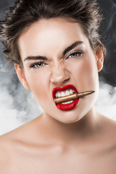 όμορφη γυναίκα κρατώντας σφαίρα στα δόντια, στο γκρι με καπνό - Φωτογραφία, εικόνα