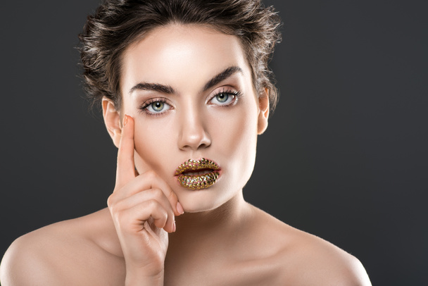beautiful pensive woman with golden lips, isolated on grey - Foto, Bild