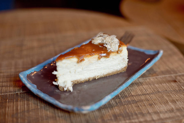 plate with slice of tasty creamy pie on wooden table, close-up  - Fotó, kép