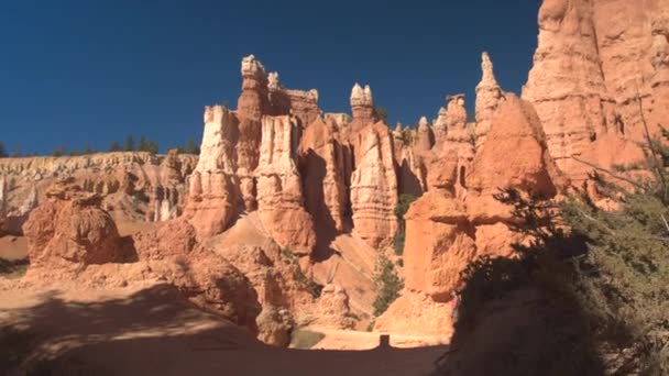 Pusty wąską ścieżką zwiedzania majestatycznych hoodoo formacje w Panguitch w stanie Utah słoneczny turysta kobieta nie do poznania. Młoda kobieta turysta turystyka zapylonych szlakach w Bryce Canyon - Materiał filmowy, wideo
