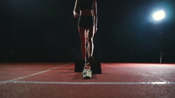 Nahaufnahmen der Beine des Athleten nähern sich dem Laufband und bringen sich in Position, um das Rennen zu starten - Filmmaterial, Video
