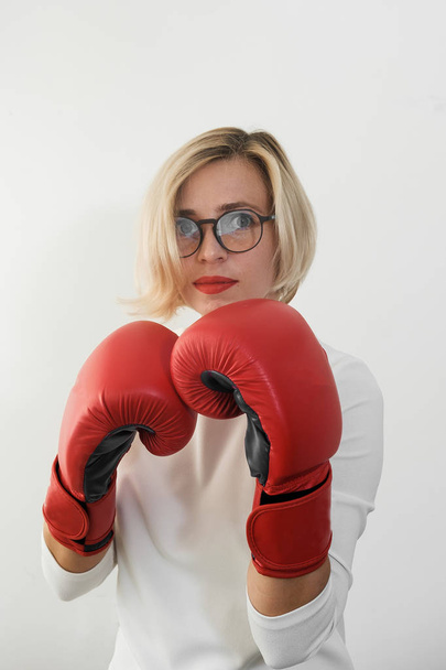 young woman with red boxing gloves. Girl in red dress are fighting, attacking and protecting.  Feminism, girl power, fight like girl, gender, woman rights concept  - Foto, imagen