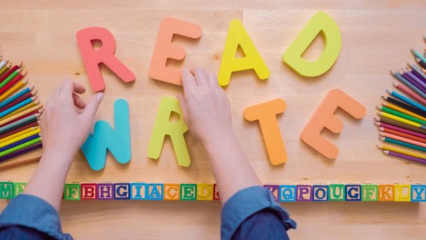 Wörter lesen und schreiben aus bunten Holzbuchstaben auf Holztisch. - Foto, Bild