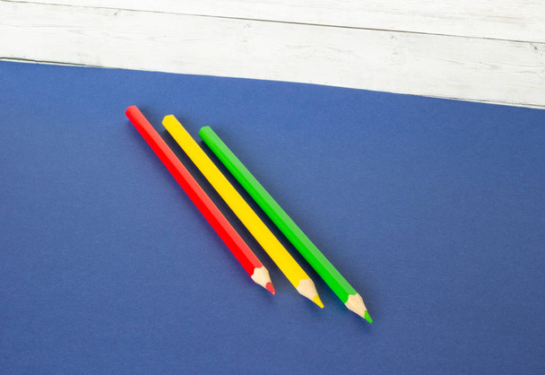 Красный, желтый и зеленый карандаши на деревянном фоне
 - Фото, изображение