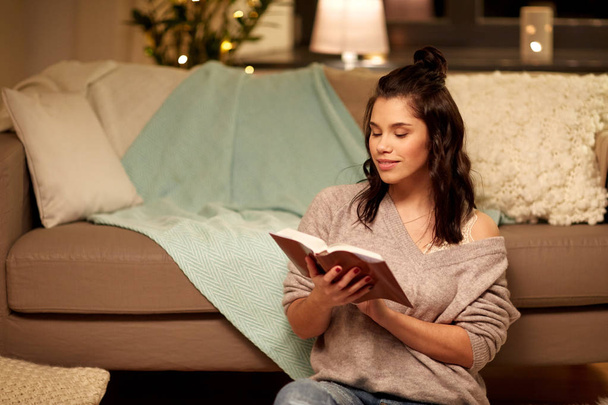 boldog fiatal nő olvasás könyv otthon - Fotó, kép