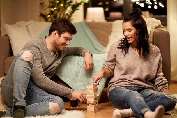happy couple playing block-stacking game at home - Foto, afbeelding