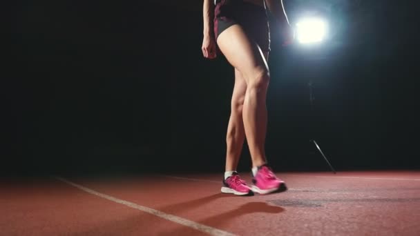 Las piernas de primer plano del atleta se acercan a la cinta de correr y se ponen en posición para comenzar la carrera
 - Imágenes, Vídeo