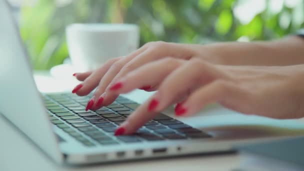 Female young hands with neat red manicure print on the laptop keyboard - Footage, Video