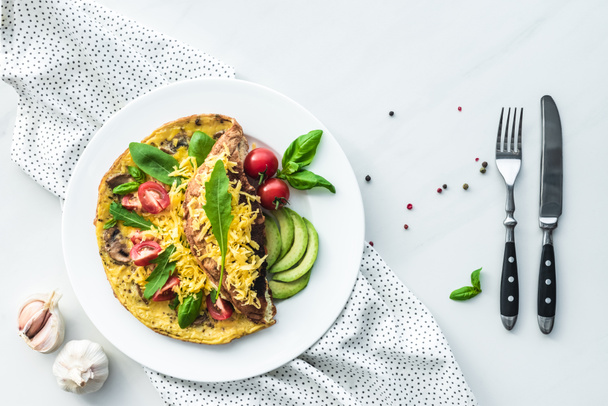 pohled shora na omeletu k snídani a příbory na bílý mramor povrch - Fotografie, Obrázek