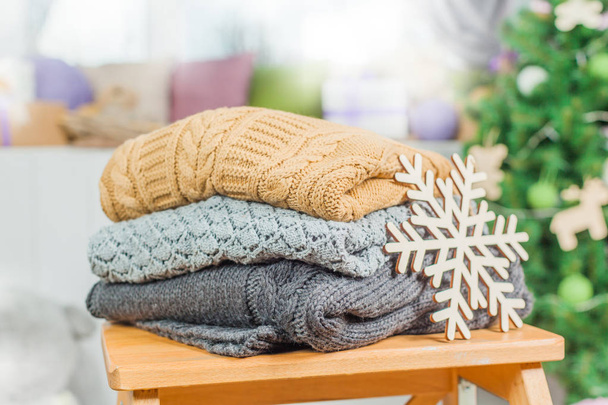 Stack of white cozy knitted sweaters on a wooden table - Foto, Bild