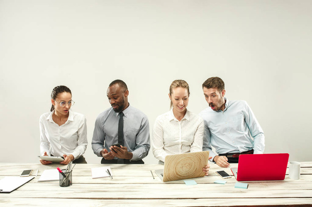 Jovens homens e mulheres sentados no escritório e trabalhando em laptops. Conceito de emoções
 - Foto, Imagem
