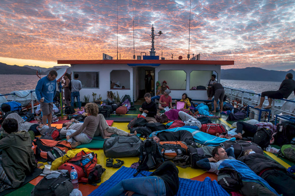 Sunrise on deck with sleeping tourists on the ferry from Wakai to Gorontalo, Sulawesi, Indonesia, Asia - 写真・画像