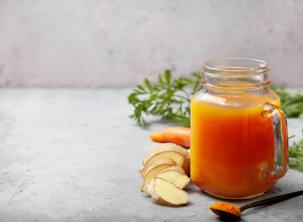 detox drink. carrot, ginger, turmeric drink in a glass on a gray background.  copy space - Фото, зображення