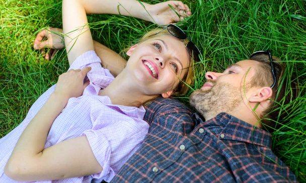 Couple in love relaxing lay at meadow. Nature fills them with freshness and peace. Guy and girl happy carefree enjoy freshness of grass. Closer to nature. Man unshaven and girl lay on grass meadow - Fotó, kép