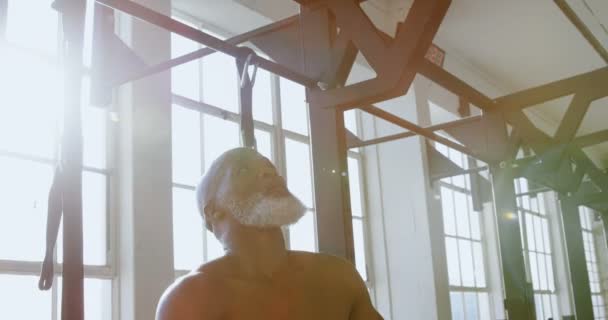 Senior man trying to pull up exercise on pull bar in the fitness studio 4k - Video, Çekim