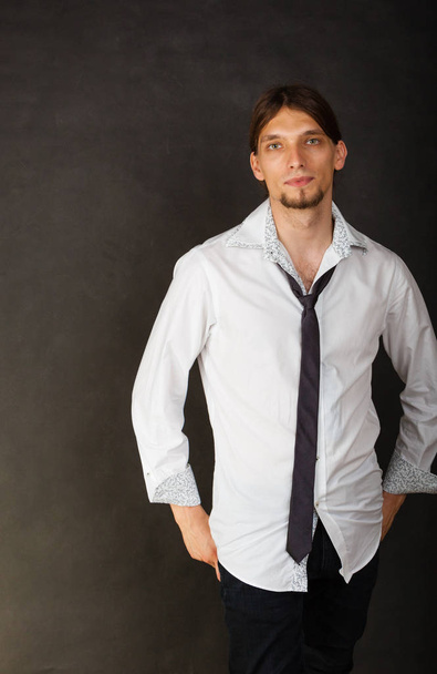 Masculinity fashion concept. Man in shirt and tie. Young long haired male on dark background.  - Valokuva, kuva