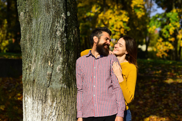 Man and woman with smiling faces on autumn trees background - Foto, immagini