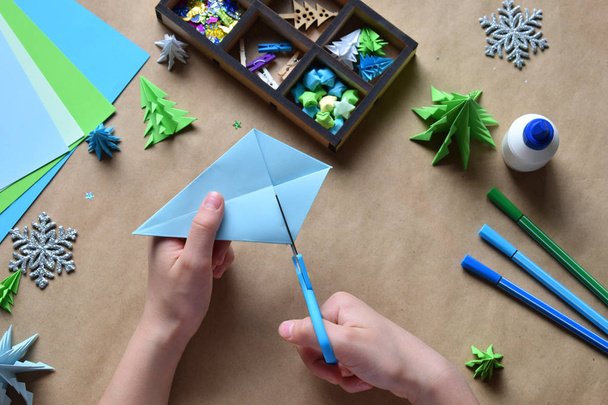 Fabrication d'origami 3D arbre de Noël avec du papier pour la décoration ou carte de vœux. Joyeux Noël et bonne année. Concept de bricolage pour enfants. Artisanat fait à la main en vacances avec vos propres mains
 - Photo, image