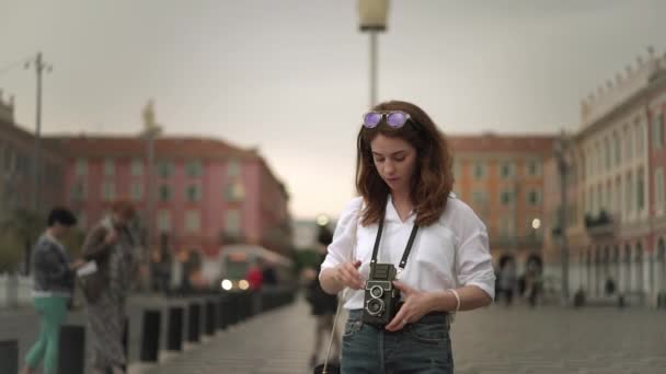 Attractive woman photographer making shots of Nice, France with vintage camera - Кадры, видео