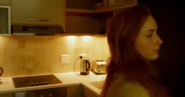 Woman opening refrigerator door in kitchen at home 4k - Video, Çekim