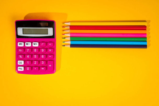 fondo amarillo con lápices de colores, calculadora, regla y rotuladores
 - Foto, Imagen