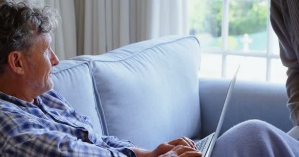 Casal sênior usando laptop no sofá em casa 4k
 - Filmagem, Vídeo