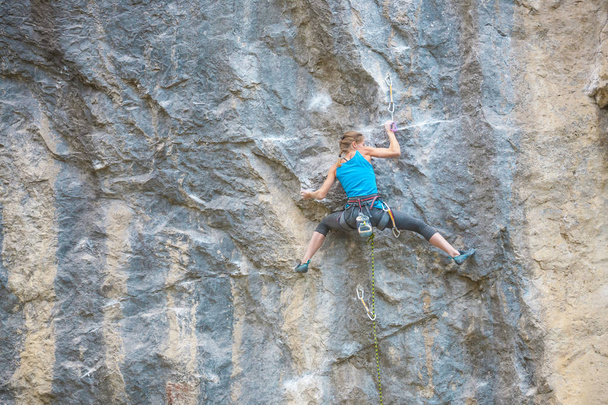 A mászó mászni a rock képzés. Egy erős lány felülemelkedő nehéz hegymászó útvonal. Aktív életmód. Extrém hobbi. Egy nő megy sportok a természetben. - Fotó, kép